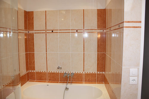 L'espace baignoire d'une salle de bain (à noter la symétrie des faïences et les angles sans baguette)